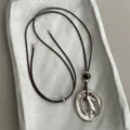 Detail view of irregular oval metal pendant necklace with leather cord and tiger eye beads. - Style 5 (Irregular Oval Pendant)