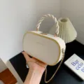 Witte ovale handtas met getwist handvat, goudkleurige rand en ketting voor vrouwen. - Broken Wit