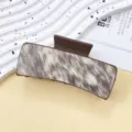 Detailed view of brown hair claw clip featuring trendy animal print texture design. - Multicolor