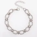 Nahaufnahme der Details des Edelstahlarmbands mit verdrehten Ovalgliedern und Karabiner. - 13x9mm twist oval dumbbell-steel color / Armband 17+5cm