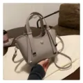 Detailaufnahme der eleganten grauen Ledertasche mit feiner Textur und Metallakzenten. - Ohne Anhänger / Grau