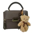 Stylish brown PU leather handbag with cute teddy bear pendant and elegant white stitching. - Brown with Pendant