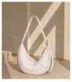 Minimalist genuine leather crescent shoulder bag detail shot, elegant soft hobo style. - Off-White