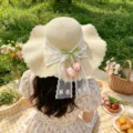 Vue détaillée du chapeau de paille français avec nœud en dentelle et pendentifs tulipes. - Taille Unique / Tulipe Beige