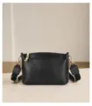 Detailed view of the black leather crossbody handbag highlighting gold zipper and strap design. - 23*11*13.5 / Black