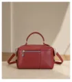 Red leather handbag detail shot highlighting fine texture, front zipper pocket, handle. - Burgundy