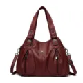 Elegante bordeauxlederen dames schoudertas met twee handvatten en voorvakken met rits. - Rood