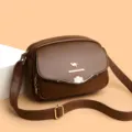 Nahaufnahme der braunen PU-Leder Damen Umhängetasche mit Kleeblatt-Schnalle und Gurt. - Braun