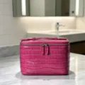 Vista detallada del neceser de cuero rosa con motivo de cocodrilo y cremallera de doble sentido. - 23x14x15cm / Rojo Rosa Brumoso