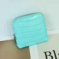 Detailed view of mint green crocodile pattern leather coin purse and jewelry storage pouch. - Lake Blue