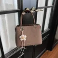 Elegante bolso de mano marrón tejido con bonito colgante de flor para uso diario. - Marrón