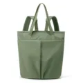 Green nylon convertible tote backpack detail showing front pockets and dual carry straps construction. - Moss Green