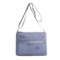 Trendy women's nylon cross-body bag with multiple zip compartments and water-repellent finish. - Light Blue