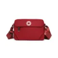 Detailed view of the red nylon casual cross-body bag, lightweight fabric and adjustable strap. - S / Red