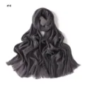 Crinkled scarf detail showing fine texture, elegant dark grey fabric and delicate fringe edges. - Dark Gray