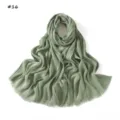 Detailed view of the sage green crinkled scarf with stylish fringed edges and soft drape. - Light Green