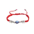 Gros plan détail du bracelet cordon tressé rouge avec perle mauvais œil et breloques éléphant. - Éléphant Argent (Corde Rouge)