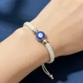 Bracelet tressé réglable mauvais œil avec perle bleue et accents métalliques argentés. - Mauvais Œil avec Perles de Fin (Corde Blanche)