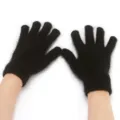 Primo piano di guanti in maglia nera pelosi che mostrano una consistenza morbida e polso caldo. - Nero