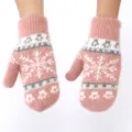 Close up detail of pink plush winter mittens with cute snowflake knit pattern warm cozy wear. - Pink