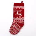 Detailed view of the red knit Christmas stocking featuring a festive white reindeer and snowflake pattern. - 1