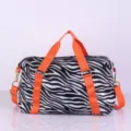 Sac de voyage zébré noir et blanc avec des poignées orange vif et une bandoulière réglable pratique. - Motif Zèbre Noir et Orange