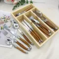 Besteckset aus Edelstahl mit Holzmaserung Griff, Detailansicht von Messern und Gabeln. - 24-teiliges Mit Holzkiste