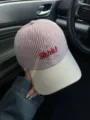 Vue détaillée d'une casquette rayée rouge et blanche élégante avec broderie Shhh et visière. - Rouge