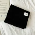 Classic black knitted winter scarf with brand label, warm and soft fabric for cold weather. - Black