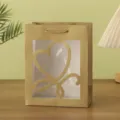 Detail view of a luxury gold gift bag with a clear window and heart cutout for packing. - 18x10x23cm / Gold