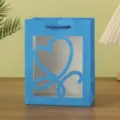 Blue paper gift bag with heart-shaped window and handles for packaging and party gifts. - 18x10x23cm / Sapphire Blue