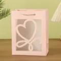 Pink paper gift bag with transparent heart window, elegant packaging for parties and festivals. - 18x10x23cm / Pink