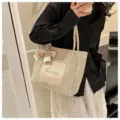 Woven straw tote bag for women, stylish summer shoulder bag with ribbon accessory. - White