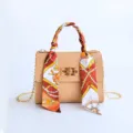 Elegante bolso de hombro beige para mujer con pañuelo de seda estampado y cierre dorado. - Caqui