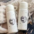 Niedlicher weisser Thermobecher im Detail, tragbare Studenten-Vakuumflasche mit Motiv. - Einzelner Becher (mit Schüsseldeckel und Trageband) / Schneeweißer Drei-Getränke-Thermobecher (Zwillingshasen)