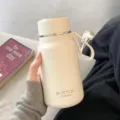 Cremewitte roestvrijstalen thermoskan met draagriem, draagbare thermische beker voor op kantoor. - Enkele Beker (met Band, Deksel en Thee-infuser) / Beige 650ML