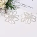 Primer plano de accesorio de joyería DIY de flor de cuentas blancas, diseño hueco, elegancia. - Blanco