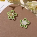 Detailed close-up of cute handmade green tube beaded flower accessories, perfect for DIY jewelry. - Green