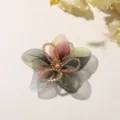 Vista detallada de la flor de cinco pétalos de organza degradada con cuentas de cristal para pelo. - Verde amarillento