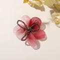 Detalle en primer plano de la flor de organza rosa degradada con centro de perlas de cristal DIY. - Rojo