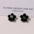 Close-up detail of vintage black pearl five-petal flower DIY alloy accessories for crafts. - Black