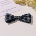 Blue and white plaid bow hair clip with vintage silver cross metal detail, close-up view. - L / Black and White
