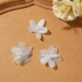 Close-up detail of light blue sheer bubble gauze five-petal flower DIY accessory and decor. - Blue
