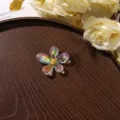 Detail shot of iridescent acrylic flower hair accessory featuring a sparkling rhinestone core. - Size 3 / 1 Piece