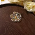 Close-up detail shot of the translucent iridescent acrylic flower accessory with gold stamen. - Size 4 / 1 Piece