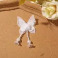 Close-up detail of white layered mesh butterfly patch with beaded tassel and faux pearls. - 1 Piece / White