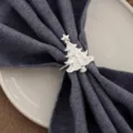 Gros plan sur l'anneau de serviette sapin de noël argenté avec des strass et un tissu bleu. - Argent
