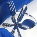 Gros plan détaillé d'un rond de serviette en métal argenté avec décor de couverts croisés. - Argent