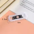 Nahaufnahme Detailansicht des weißen spitzenbestickten Aufnähers mit schwarzen Buchstaben. - Stil 10