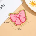 Detailed close-up of the pink bow towel embroidery patch with sparkling gold glitter border. - Style 5